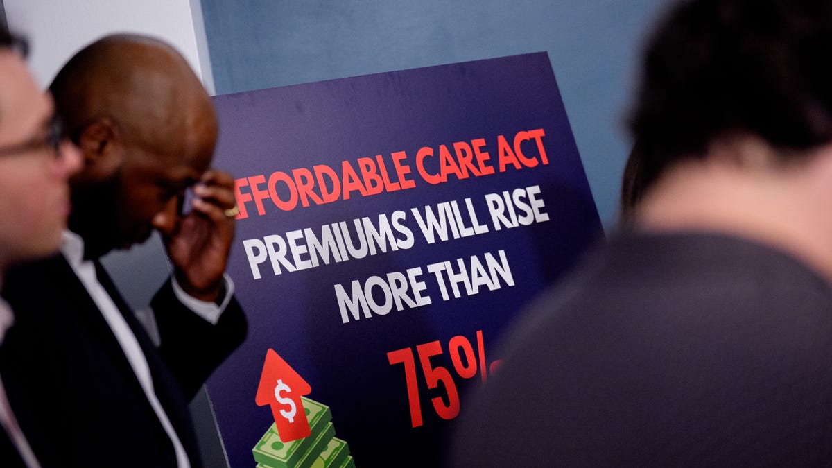 Lester Johnson (L), a restaurant owner in Richmond, Virginia, stands next to a sign that reads "Affordable Care Act Premiums Will Rise More Than 75%" during a news conference to call on Republicans to pass Affordable Care Act tax breaks on Capitol Hill on September 16, 2025 in Washington, DC. Democratic Senators joined Protect Our Care and advocates to call on the GOP to protect health care for Americans and stop premium hikes.