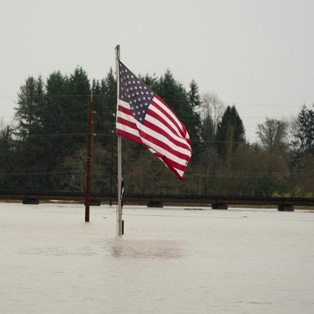 Floodwaters from the Snohomish River surround a U.S. flag, as an atmospheric river brings rain and flooding to the Pacific Northwest, in Snohomish, Washington, December 11, 2025.