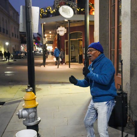 Performer Onunze Ubaka sings to a nearly deserted street in the French Quarter of New Orleans on Dec. 5, 2025.