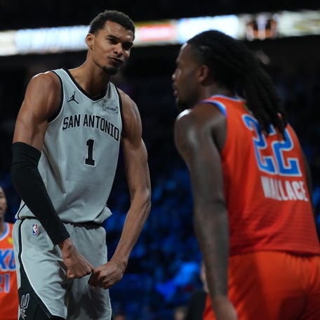 San Antonio Spurs forward Victor Wembanyama (1) flexes in front of Oklahoma City Thunder guard Cason Wallace (22) during the third quarter at T-Mobile Arena.