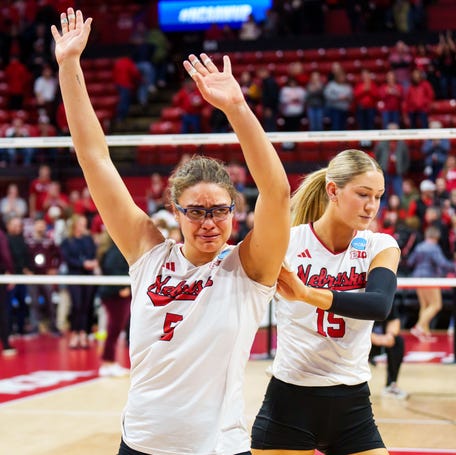 Nebraska middle blocker Rebekah Allick (5) waves to fans while walking off the court with middle blocker Andi Jackson (15).