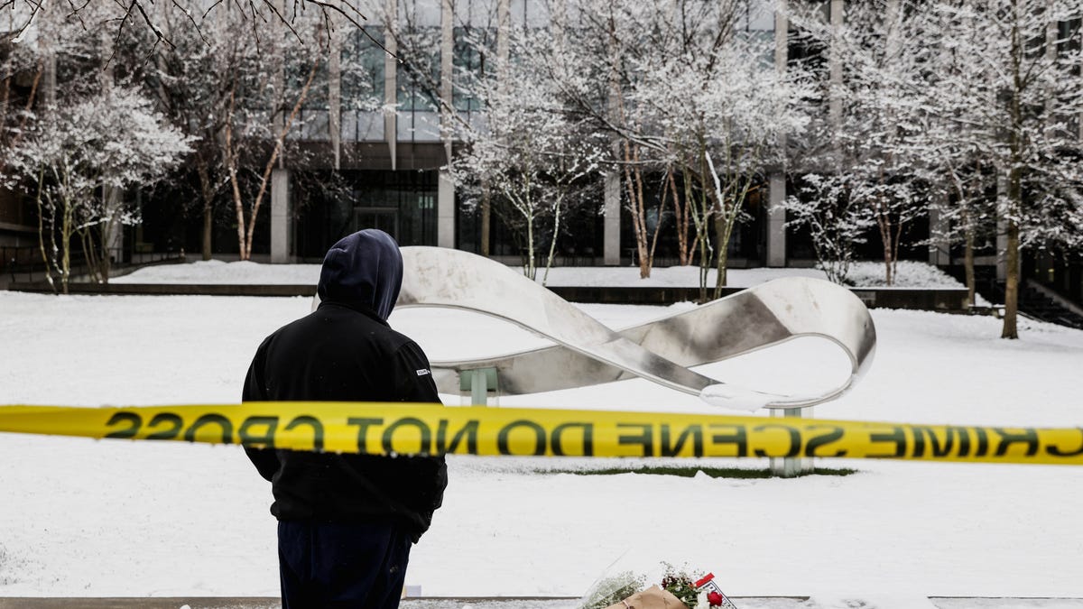 Marc Sorel, a member of the community, takes a moment after writing PEACE in the snow in front of the Barus & Holley engineering building, the day after Brown University was locked down amid reports of a shooting on campus in Providence, Rhode Island, Dec. 14, 2025.