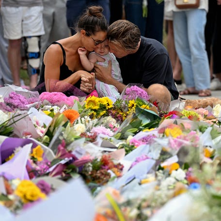 Mourners visit a floral tribute to Bondi Beach shooting victims in Sydney, Australia, on Dec. 15, 2025, the day after two gunmen attacked a Hanukkah event. The assault, which killed 15 victims, is Australia's worst mass shooting in nearly 30 years and is being investigated as an act of terrorism targeting the Jewish community.