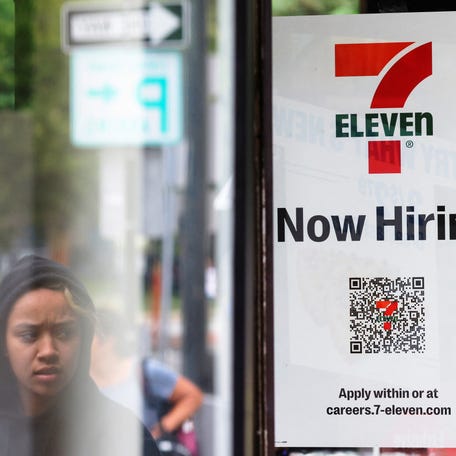 A 7-Eleven convenience store has a sign in the window reading "Now Hiring" in Cambridge, Massachusetts, U.S., July 8, 2022. REUTERS/Brian Snyder