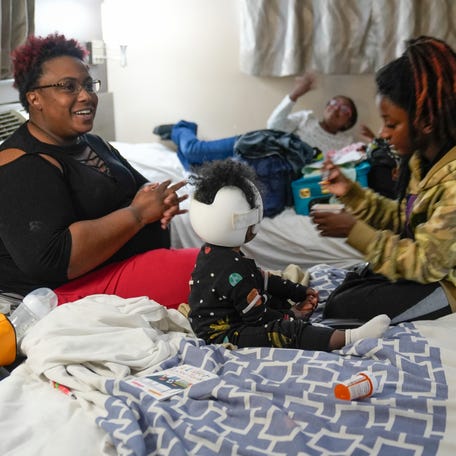 Johnika Jamison, left, with her three daughters Eden, 15 Eastin , 9 and Everly, 1, and her husband Tristian Harris, back right, in the small hotel room they call home. Jamison married Harris, Everly's father, in December 2024. The family has been homeless for more than a year after Jamison and her husband experienced medical troubles that put them out of work.