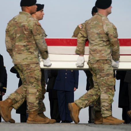President Donald Trump salutes as members of the military carry a transfer case, during a dignified transfer of the remains of two Iowa National Guard members killed in Syria, Sgt. Edgar Torres Tovar and Sgt. William Howard, and Ayad Mansoor Sakat, of Macomb, Michigan, who was working as an interpreter in Syria, at Dover Air Force Base in Dover, Delaware, on Dec. 17, 2025.