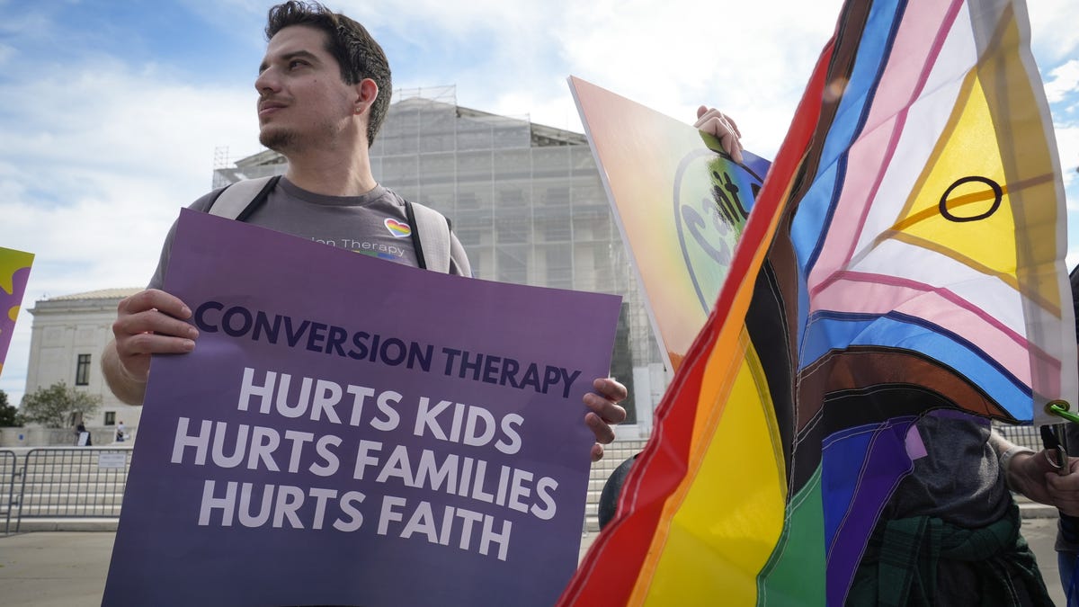 Protesters rally outside the Supreme Court as the justices hears oral arguments on whether Colorado's ban on providing conversion therapy to LGBTQ+ children violates a private therapist's rights to free speech in Washington, D.C., on October 7, 2025.