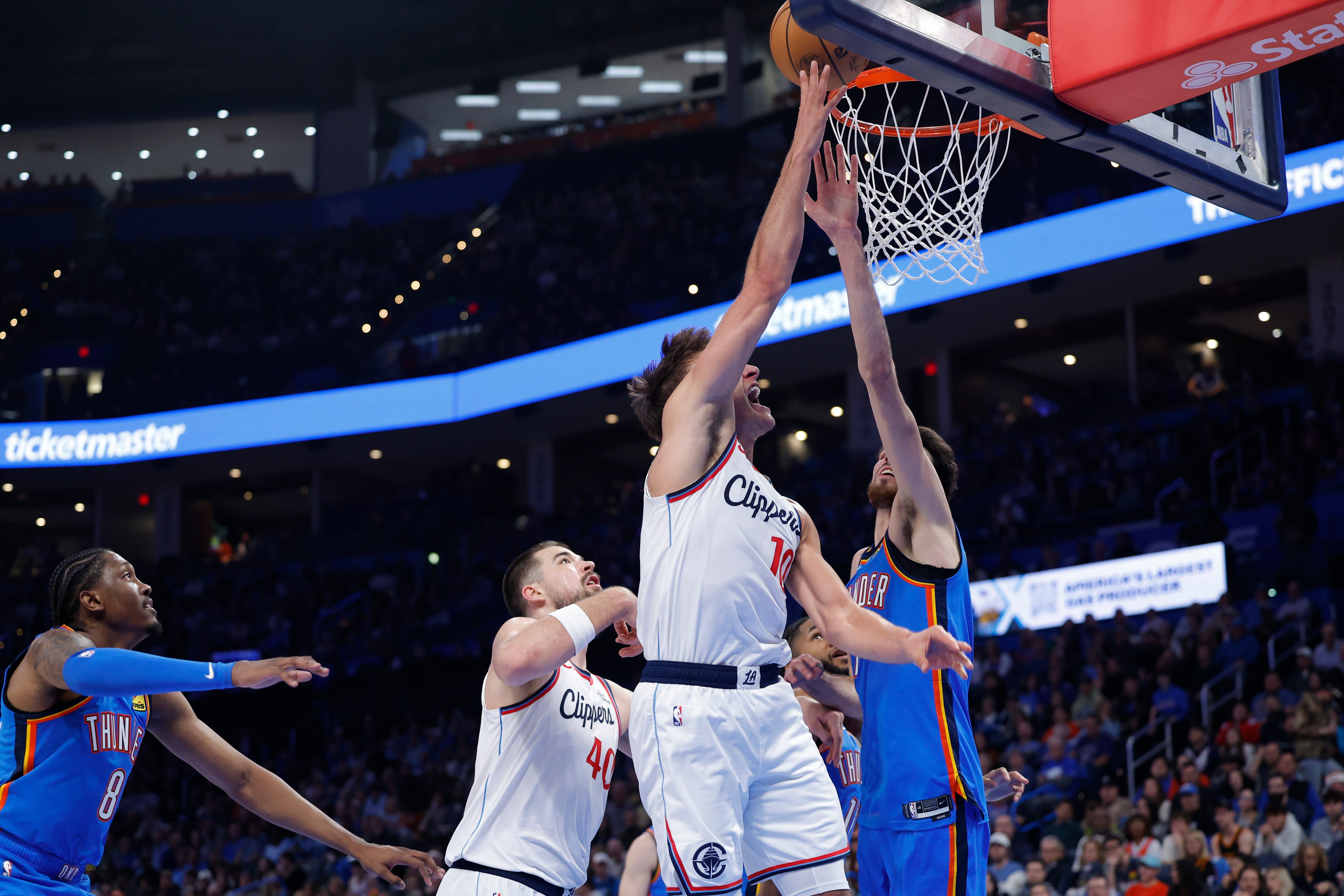 Dec 18, 2025; Oklahoma City, Oklahoma, USA; Los Angeles Clippers guard Bogdan Bogdanovic (10) goes up for a basket as Oklahoma City Thunder center Chet Holmgren (7) defends during the second half at Paycom Center. Mandatory Credit: Alonzo Adams-Imagn Images