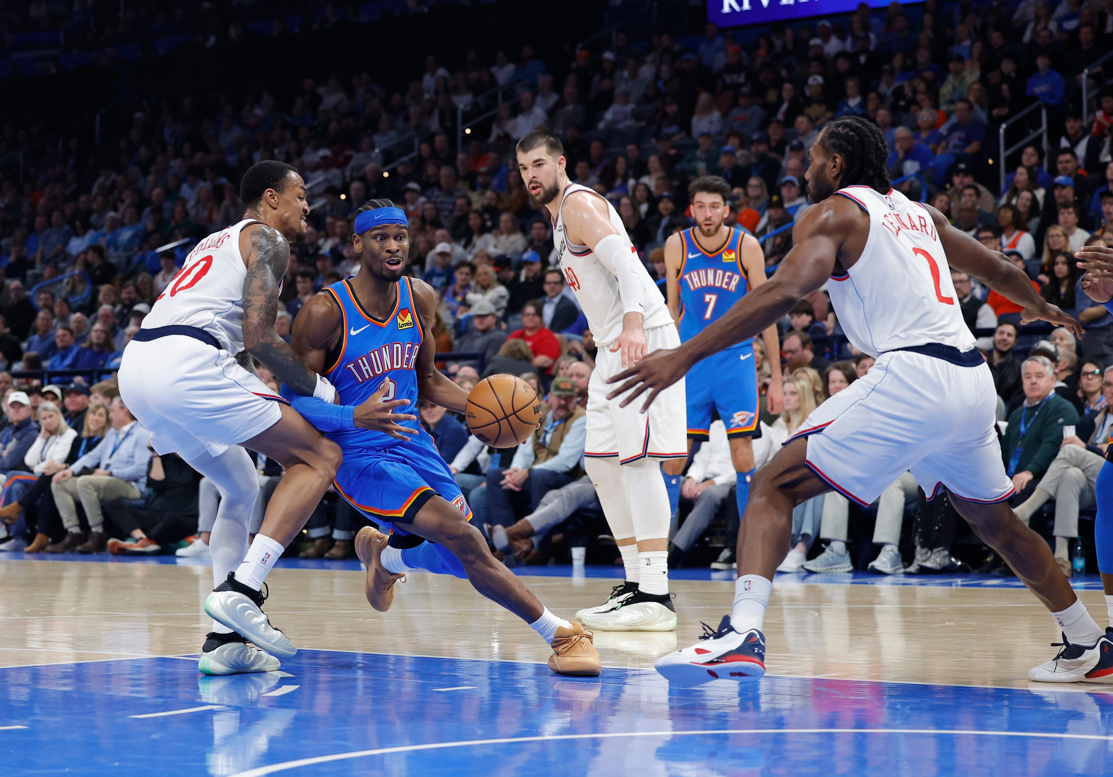 Dec 18, 2025; Oklahoma City, Oklahoma, USA; Oklahoma City Thunder guard Shai Gilgeous-Alexander (2) drives to the basket between Los Angeles Clippers forward John Collins (20) and forward Kawhi Leonard (2) during the second quarter at Paycom Center. Mandatory Credit: Alonzo Adams-Imagn Images