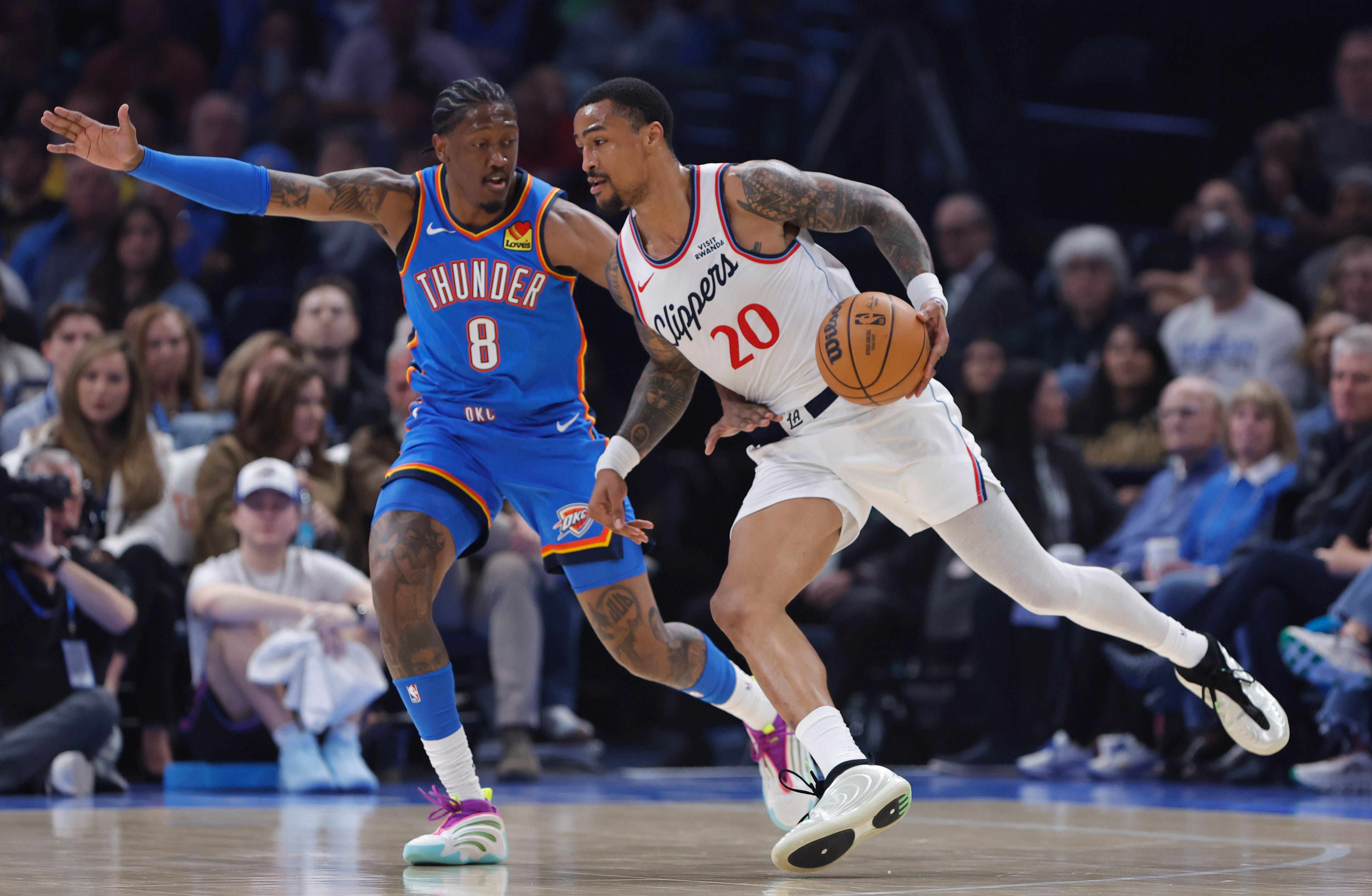 Dec 18, 2025; Oklahoma City, Oklahoma, USA;Los Angeles Clippers forward John Collins (20) moves the ball around Oklahoma City Thunder guard Jalen Williams (8) during the first quarter at Paycom Center. Mandatory Credit: Alonzo Adams-Imagn Images