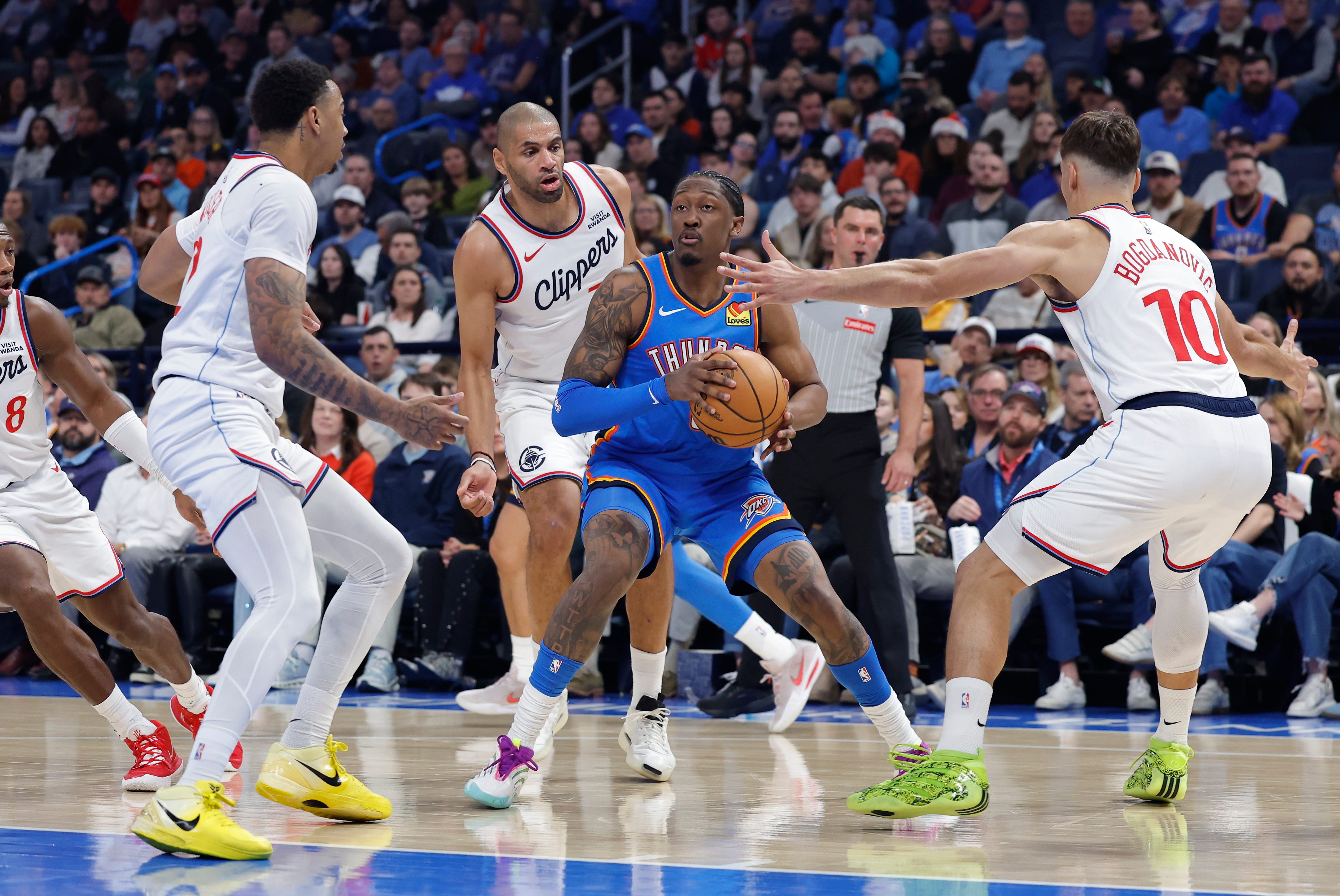 Dec 18, 2025; Oklahoma City, Oklahoma, USA;Oklahoma City Thunder guard Jalen Williams (8) moves the ball between Los Angeles Clippers guard Jordan Miller (22), and guard Bogdan Bogdanovic (10) during the second quarter at Paycom Center. Mandatory Credit: Alonzo Adams-Imagn Images