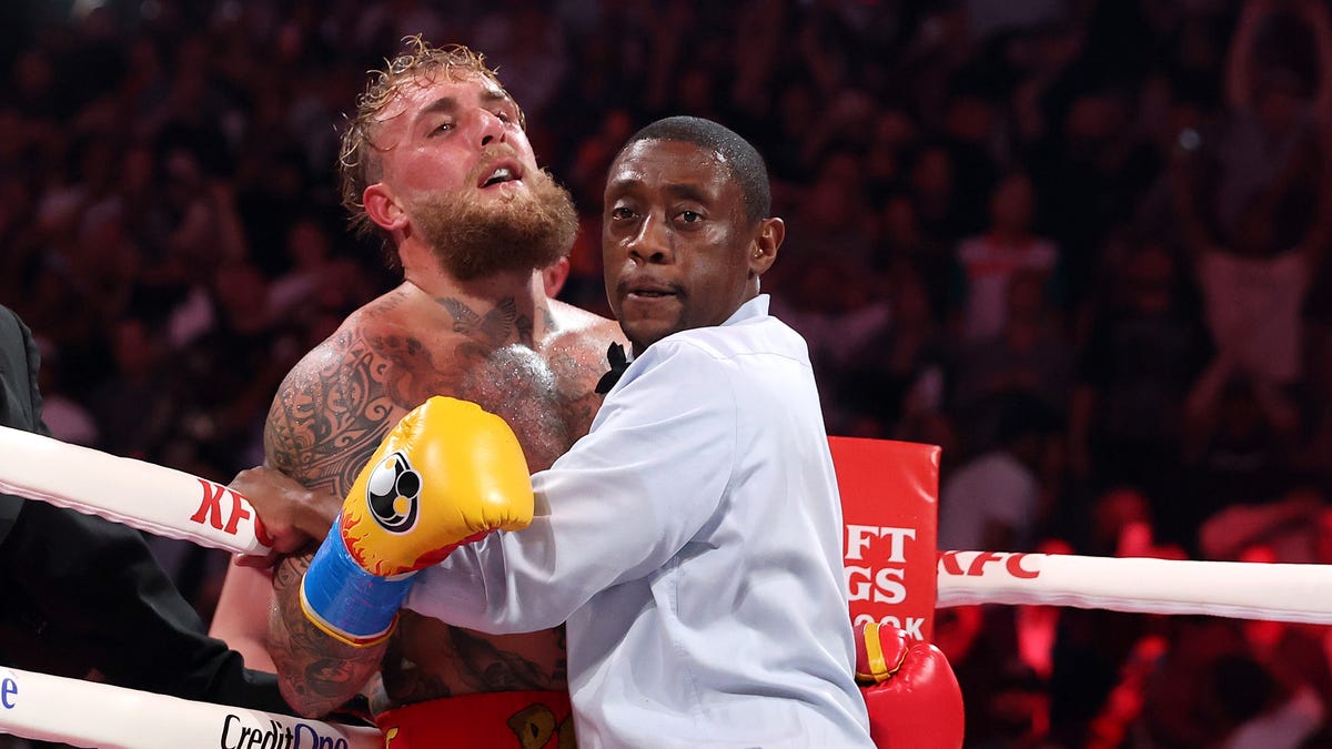 Jake Paul is held back by the referee against Anthony Joshua in their heavyweight bout.