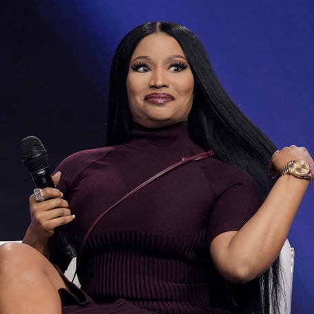 Nicki Minaj speaks with Erika Kirk during a surprise appearance at AmericaFest, the first Turning Point USA conference since the death of Charlie Kirk, in Phoenix on Dec. 21, 2025.