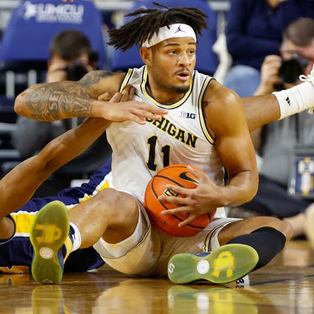 Michigan guard Roddy Gayle Jr. (11) fights for control of the ball with La Salle guard Eric Acker (3) during their game at Crisler Center.
