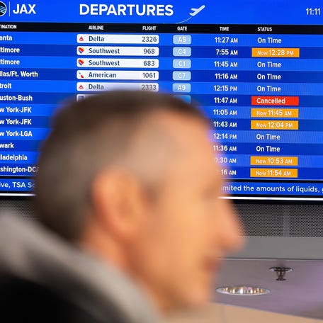 A air traveler checks out the flight board to see if his flight was on time, delayed or cancelled at the Jacksonville International Airport Tuesday morning, January 21, 2025.
