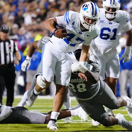 Brigham Young quarterback Bear Bachmeier (47) tries to avoid the tackle of Colorado defensive lineman Amari McNeill (88) during their game at Folsom Field.