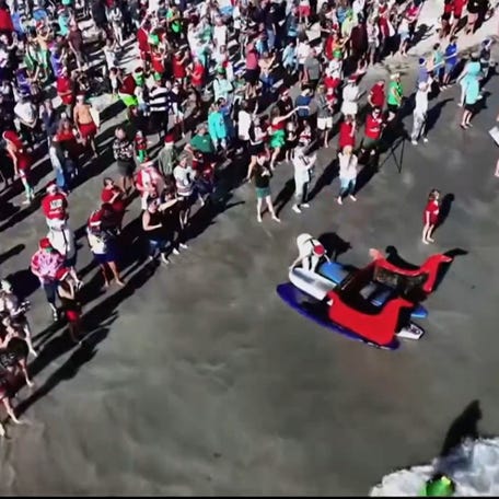 Hundreds of Surfing Santas ride Cocoa Beach waves to raise funds for cancer treatment and the Florida Surf Museum.