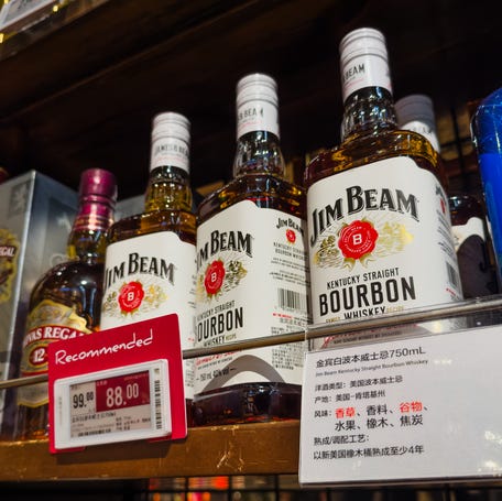 Bottles of Jim Beam Kentucky Straight Bourbon Whiskey, an American-made spirit produced in Kentucky, are displayed for sale on a supermarket liquor shelf, alongside other imported alcoholic beverages, on April 12, 2025 in Shenzhen, China.