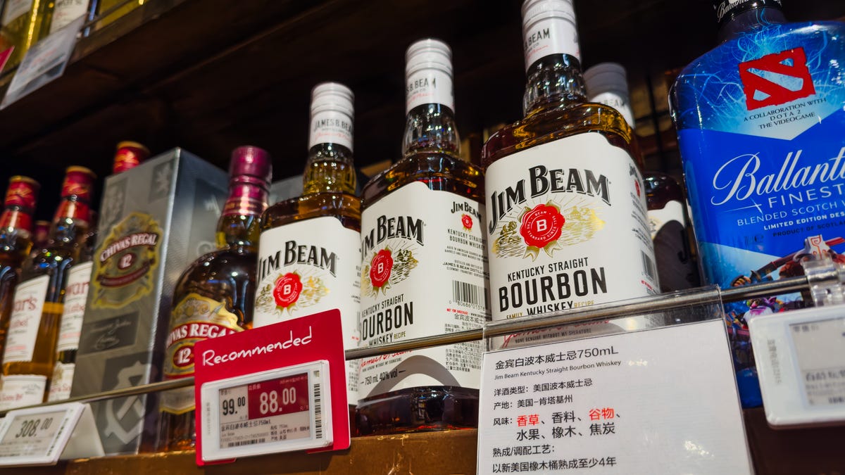 Bottles of Jim Beam Kentucky Straight Bourbon Whiskey, an American-made spirit produced in Kentucky, are displayed for sale on a supermarket liquor shelf, alongside other imported alcoholic beverages, on April 12, 2025 in Shenzhen, China.