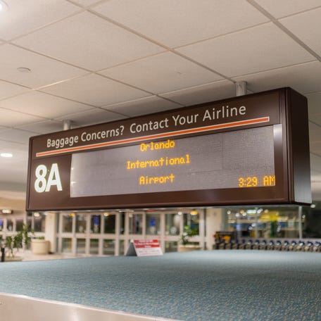 Airport signboard displaying Orlando International Airport in yellow letters.