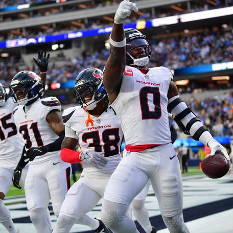 Dec 27, 2025; Inglewood, California, USA; Houston Texans linebacker Azeez al-Shaair (0) reacts with safety K'Von Wallace (38) after making an interception against the Los Angeles Chargers during the first half at SoFi Stadium. Mandatory Credit: Gary A. Vasquez-Imagn Images