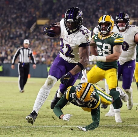 Derrick Henry #22 of the Baltimore Ravens scores a touchdown past Carrington Valentine #24 of the Green Bay Packers in the second quarter at Lambeau Field on December 27, 2025 in Green Bay, Wisconsin.