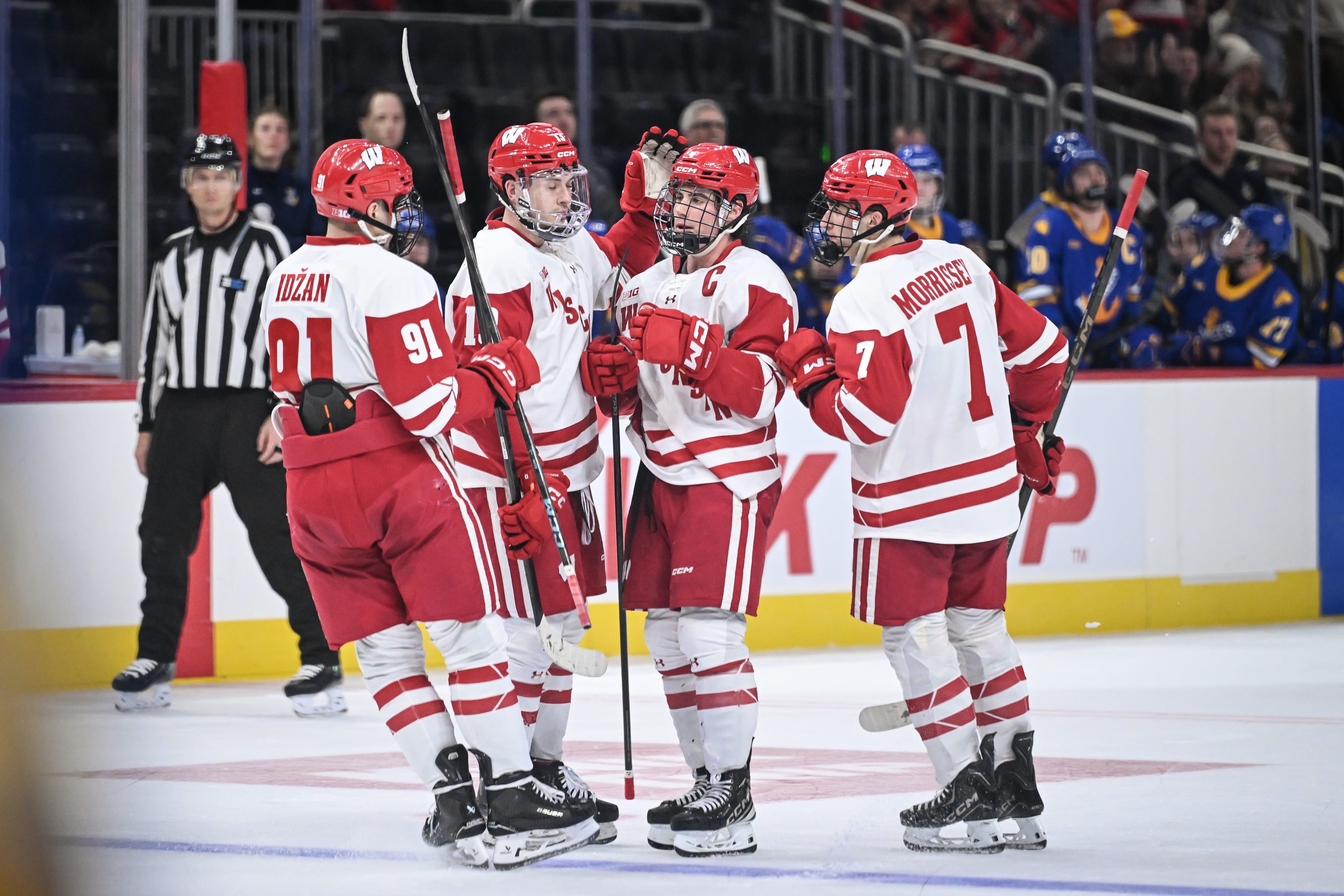 Teammates surround Wisconsin defenseman Ben Dexheimer (4) after this goal during the second period against Lake Superior State. The goal tied the game, 2-2.