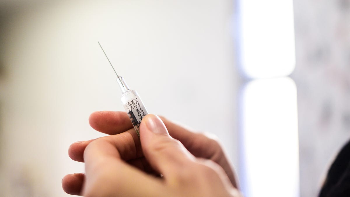 Close-up view of a pharmacist's hand holding a pre-filled syringe of flu vaccine before injection in a pharmacy in Pau, France, on Dec. 8, 2025.
