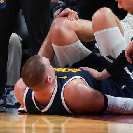 Denver Nuggets center Nikola Jokic (15) is looked at by trainers after an injury against the Miami Heat during the second quarter Dec 29, 2025 at Kaseya Center.