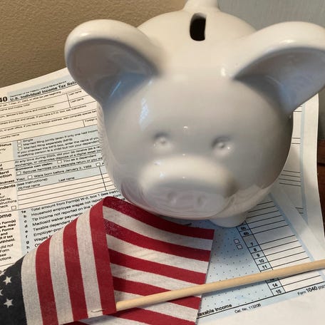 A photo illustration shows tax forms as the period to file returns or extensions with the IRS approaches.