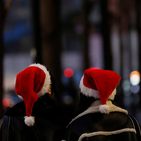 Women wearing Santa Claus hats make their way at a shopping district in Tokyo, Japan, December 25, 2025.