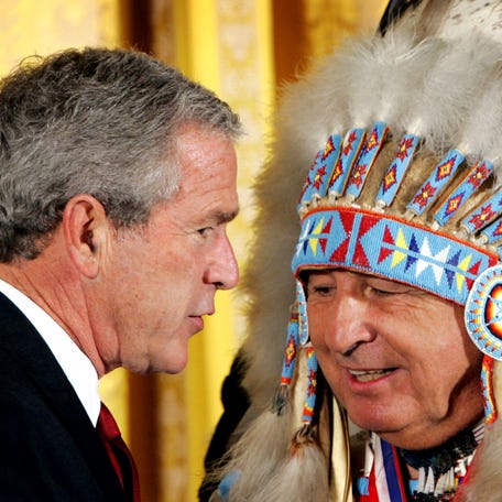Dressed in his native Northern Cheyenne wardrobe, Sen. Ben Nighthorse Campbell (R-CO) introduces U.S President George W. Bush to speak at an event in the East Room of the White House in September 2004. The event was held to honor the Opening of the National Museum of the American Indian in Washington. Campbell is the only American Indian presently serving in the United States Senate, and is one of 44 Chiefs of the Northern Cheyenne Tribe.
