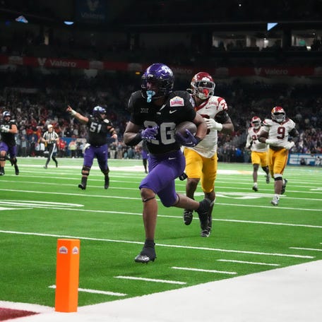 TCU Horned Frogs running back Jeremy Payne (26) scores on a 35-yard touchdown reception in overtime for the winning score against the Southern California Trojans during the Alamo Bowl.