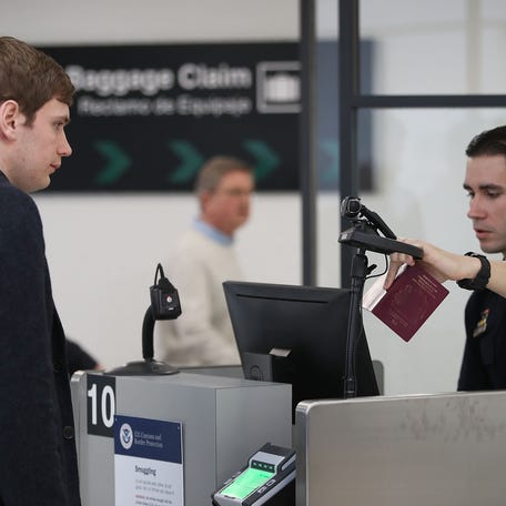A U.S. Customs and Border Protection officer instructs an international traveler to look into a camera as he uses facial recognition technology to screen a traveler entering the United States on Feb. 27, 2018, at Miami International Airport in Miami, Florida.