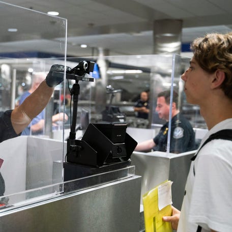 A U.S. Customs and Border Protection officer photographs a traveler arriving from Germany, using facial recognition biometrics upon entering U.S. Customs and Border Protection at McNamara Terminal at Detroit Metro Airport in Romulus on July 28, 2023.