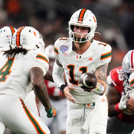 Miami Hurricanes quarterback Carson Beck (11) hands off to running back Mark Fletcher Jr. (4) during the Cotton Bowl at AT&T Stadium in Arlington, Texas for the College Football Playoff quarterfinal game against the Ohio State Buckeyes on Dec. 31, 2025.