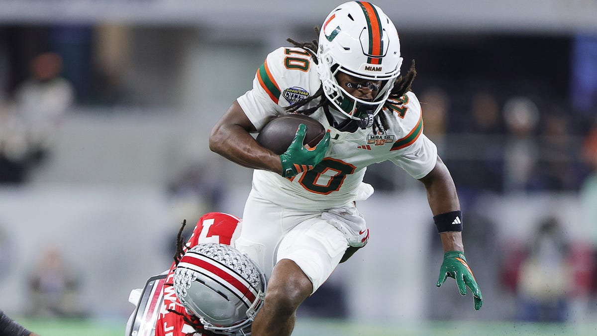 Miami receiver Malachi Toney tries to avoid the tackle of Ohio State defensive back Jermaine Mathews Jr. during their 2025 College Football Playoff quarterfinal at the Cotton Bowl.
