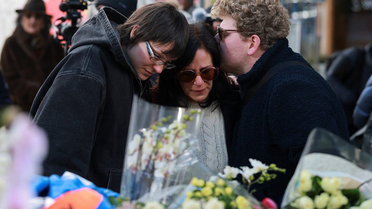 People comfort each other outside the "Le Constellation" bar after a fire and explosion during a New Year's Eve party killed dozens in Crans-Montana in southwestern Switzerland.