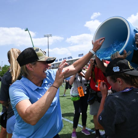 North Carolina head coach Jenny Levy dodges a dousing after the Tar Heels defeated Boston College in the 2022 Division I lacrosse championship.