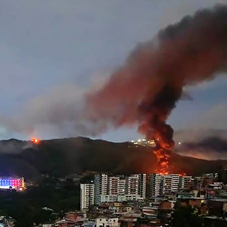Fire at Fuerte Tiuna, Venezuela's largest military complex, is seen from a distance after a series of explosions in Caracas on January 3, 2026.
