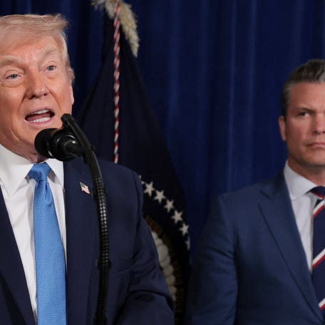 President Donald Trump speaks as Secretary of Defense Pete Hegseth looks at him during a press conference following a U.S. strike on Venezuela where President Nicolas Maduro and his wife, Cilia Flores, were captured, from Trump's Mar-a-Lago club in Palm Beach, Florida, U.S., January 3, 2026.