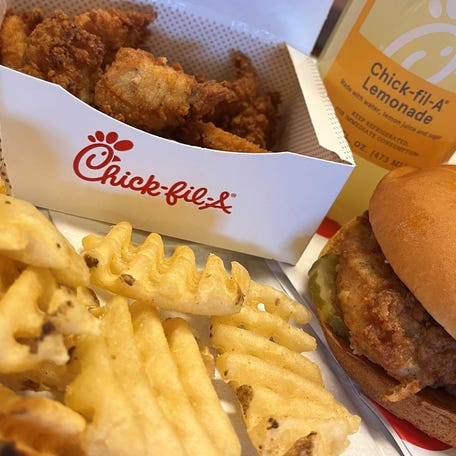 A Chick-fil-A chicken sandwich, nuggets, waffle fries and a lemonade.
