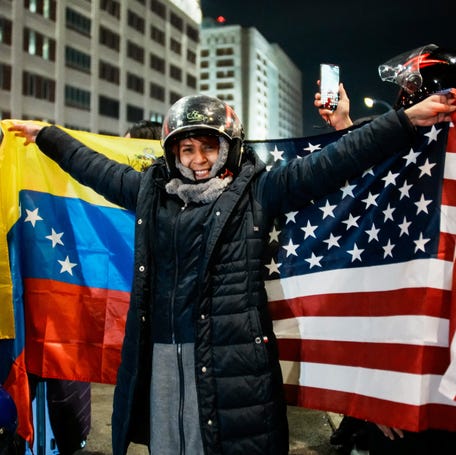 A person celebrates with Venezuelan and U.S. flags in New York City after the United States struck Venezuela on Jan. 3, 2026, capturing its president and first lady.