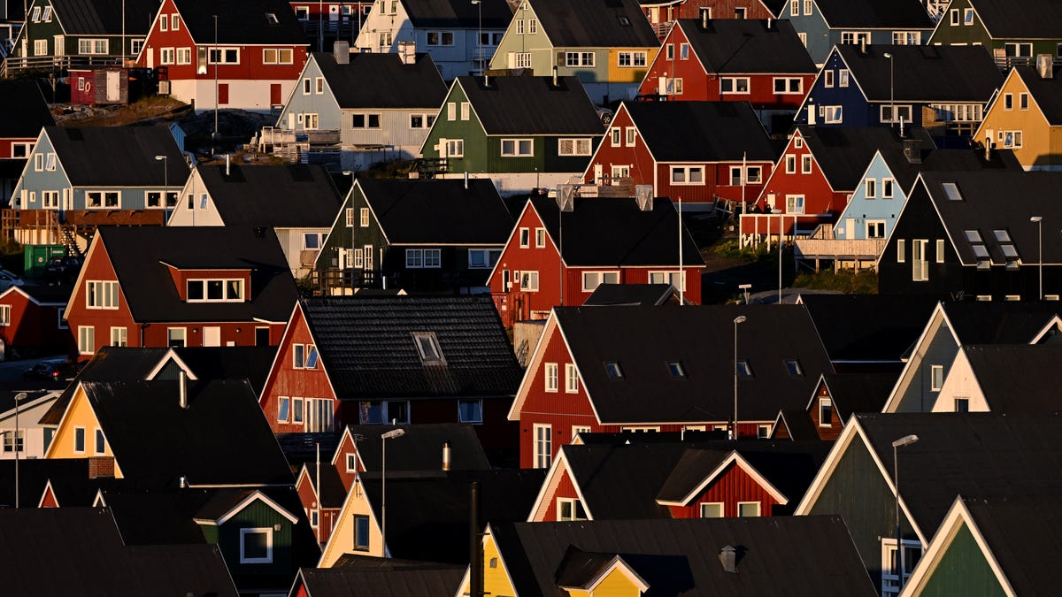 A view shows traditional Greenlandic houses illuminated by a beam of sunlight during sunset in Nuuk, Greenland, on September 23, 2025.