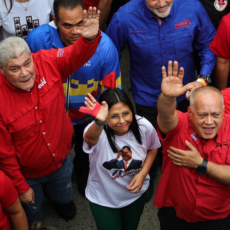 On July 28, 2025, in Caracas, Venezuela, then-Vice President Delcy Rodríguez, wearing a T-shirt with the image of the late President Hugo Chávez, waves during the commemoration of his birth. In January 2026, Rodríguez became the acting president after the U.S. military seized President Nicolás Maduro and his wife from their home.