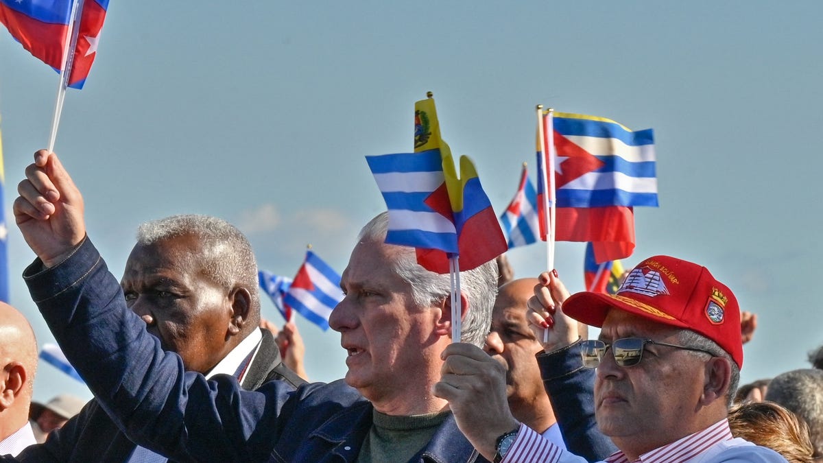 Cuba's President Miguel Diaz-Canel (C) flutters a Venezuelan and Cuban flags in support of Venezuelan leader Nicolas Maduro in Havana, Jan. 3, 2026. Cuba said 23 of its citizens - members of the military or intelligence services - were killed in the US raid that captured Maduro.