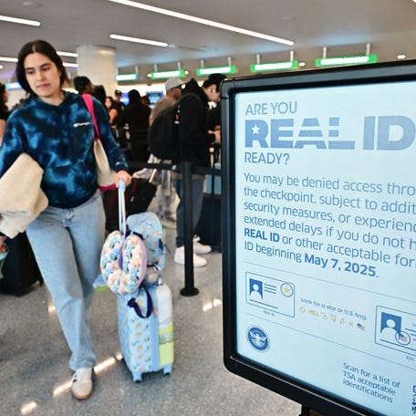 A sign reminds people of the implementation of Real ID as travelers make their way to check-in for their flights ahead of Memorial Day weekend at Los Angeles International Airport, in Los Angeles, California on May 23, 2025.