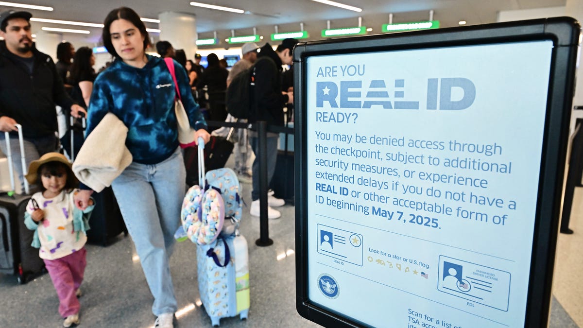 A sign reminds people of the implementation of Real ID as travelers make their way to check-in for their flights ahead of Memorial Day weekend at Los Angeles International Airport, in Los Angeles, California on May 23, 2025.
