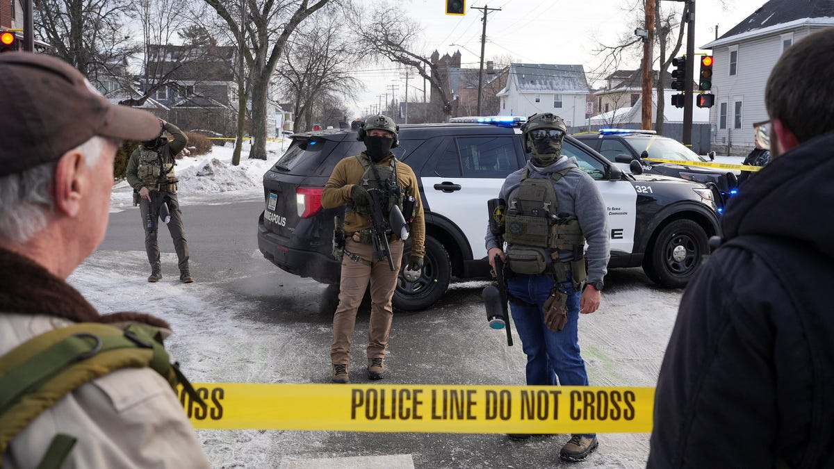 Members of U.S. Immigration and Customs Enforcement stand guard after a driver of a vehicle was shot in Minneapolis, on January 7, 2026.