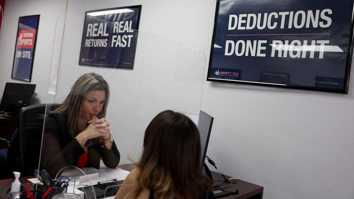 MIAMI, FLORIDA - APRIL 17: Adeleisy Perez (R) discusses her finances with Annie Cabanas, a Tax Preparation specialist, as she completes her tax filing at a Liberty Tax Service office on April 17, 2023 in Miami, Florida. April 18th is the deadline in the United States for residents to file their income tax returns. (Photo by Joe Raedle/Getty Images)